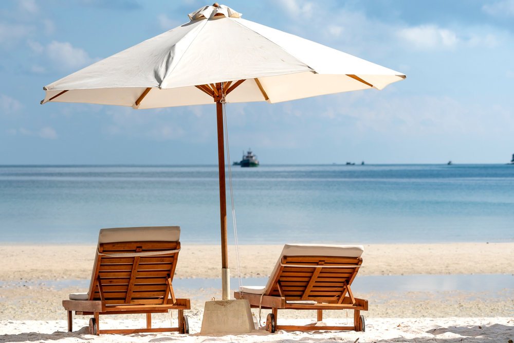 Beach umbrella with two loungers on the sand in Aruba